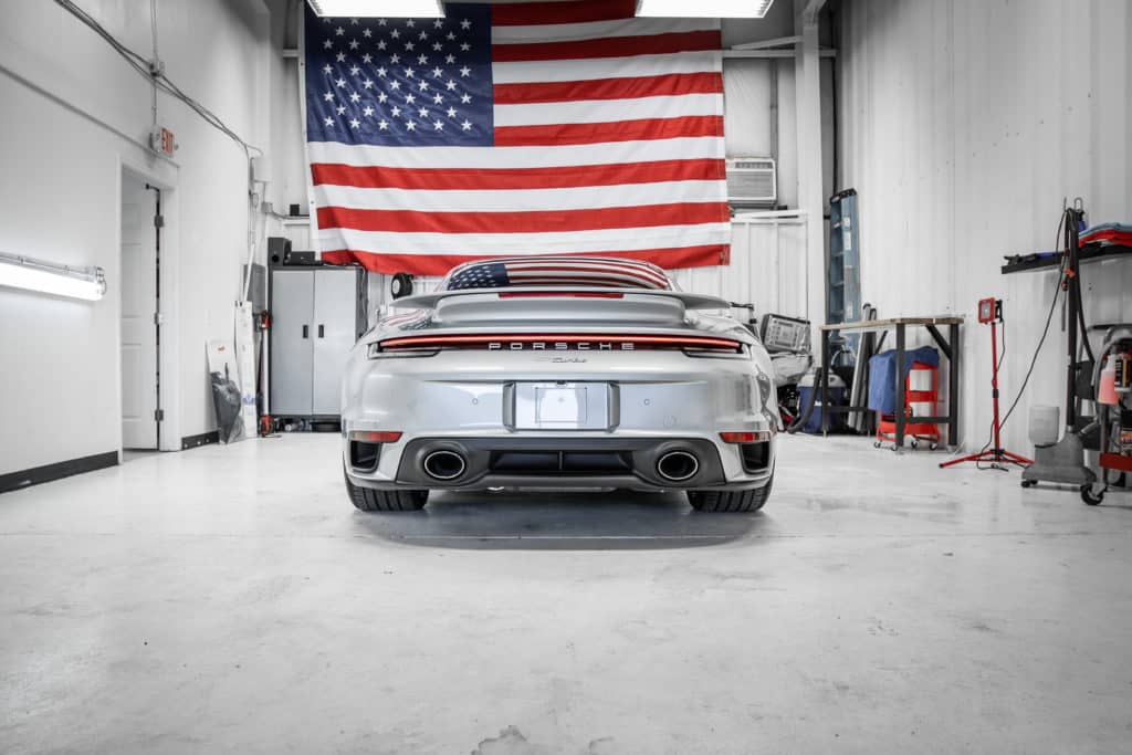 Porsche 911 Turbo sitting under an American Flag