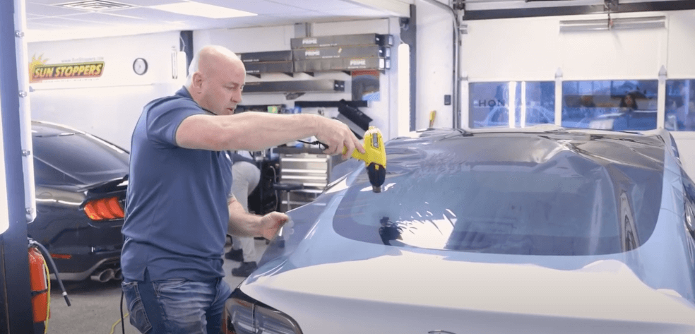 Mike Burke heating window tinting film to a Tesla