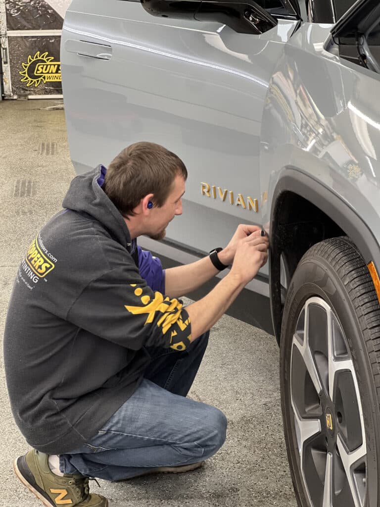 a man performing rivian window tinting and paint protection