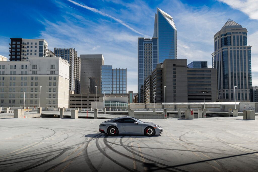 Porsche on rooftop parking garage with a city skyline in the background