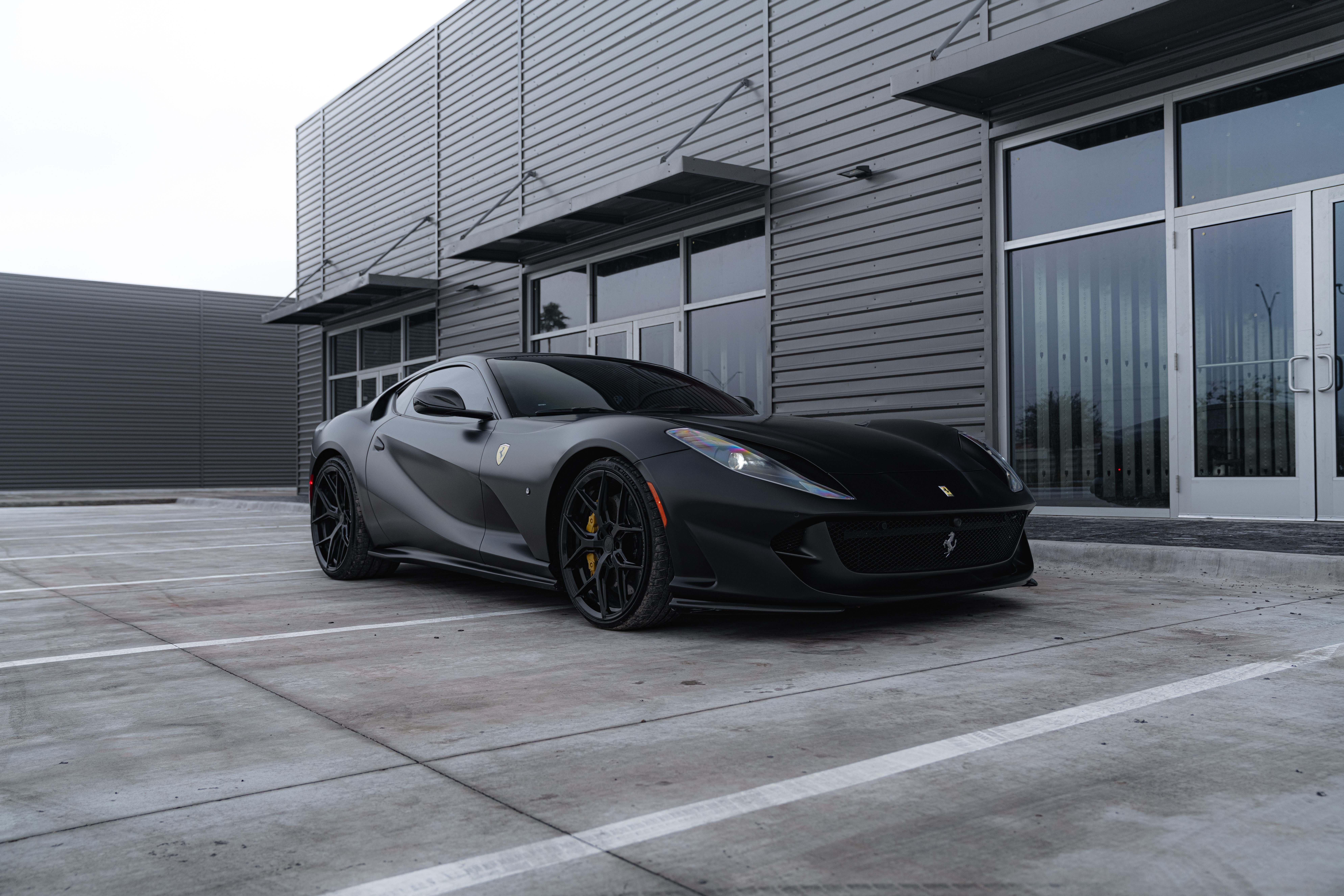 Matte black Ferrari outside auto shop