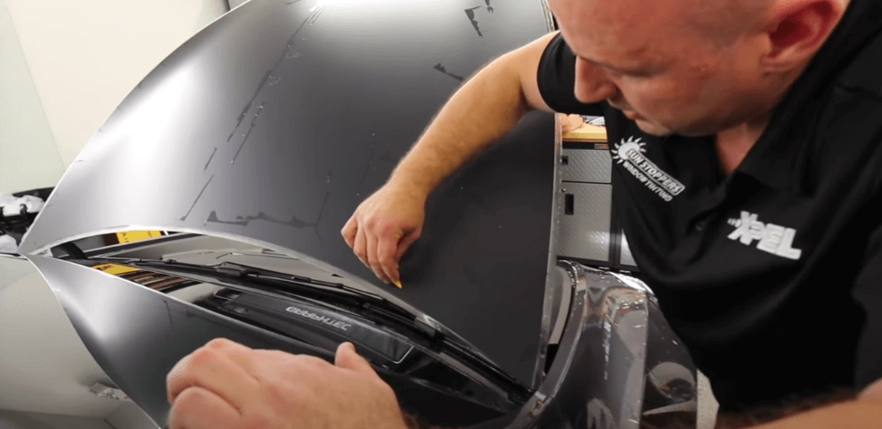 applying paint protection film to an orange Tesla
