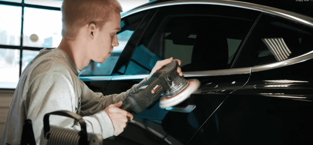 a worker preparing a Tesla for ceramic coating