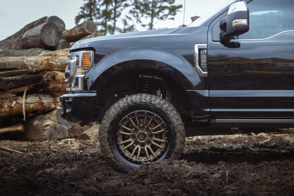 Blue truck with gold rims in the mud