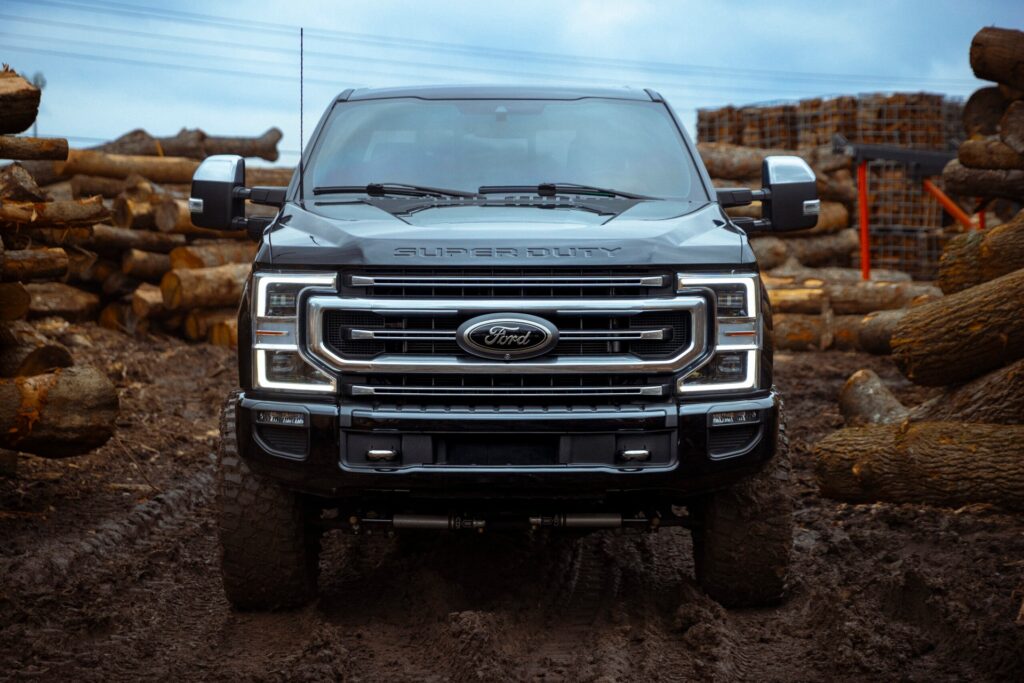 front of ford truck parked in the mud with tinted windows