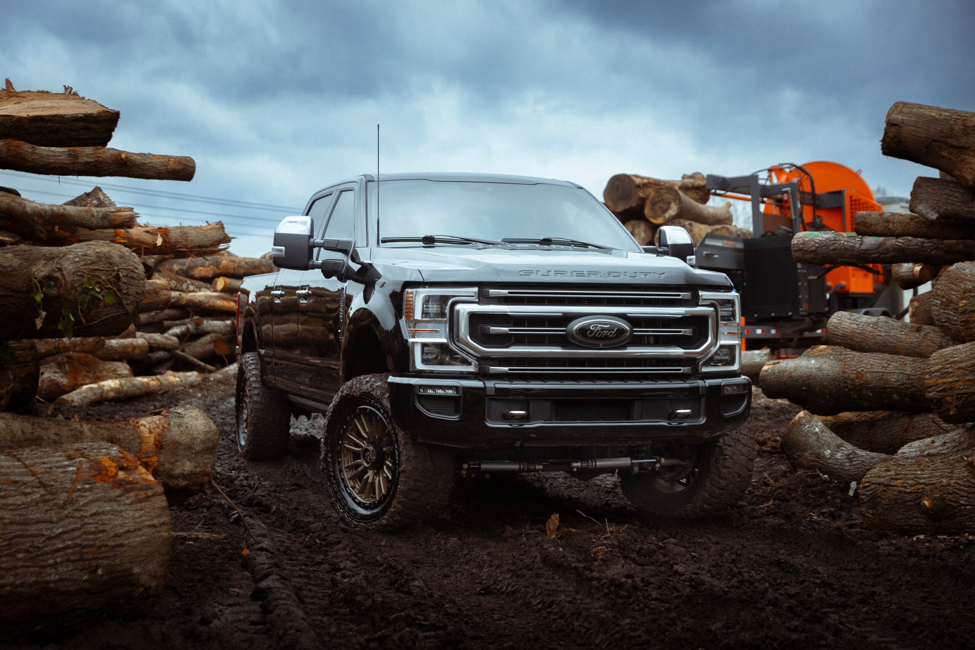 truck parked in the mud in a lumber yard with tinted windows