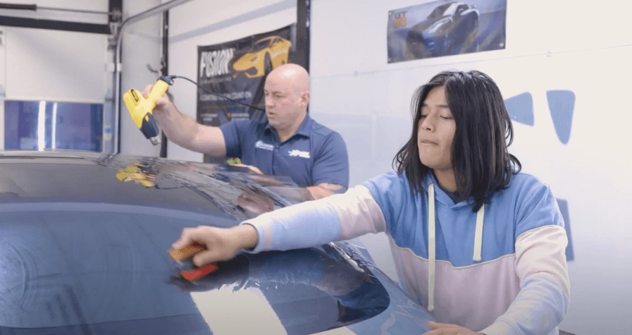 2 Sun Stoppers workers putting window tint on a Model 3 Tesla