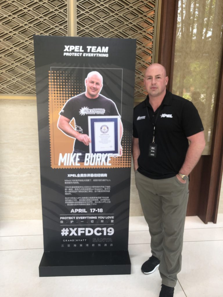 Mike Burke poses with his XPEL's Dealer of the Year poster.