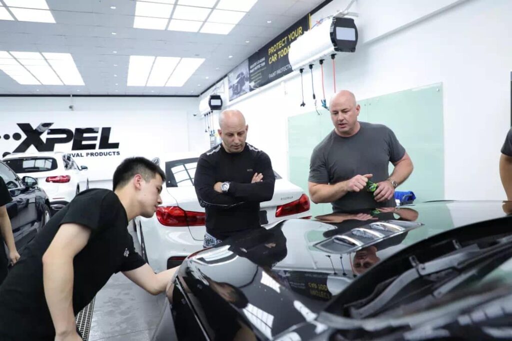 Mike Burke explains his window tinting and paint protection techniques to an XPEL Asian dealer.