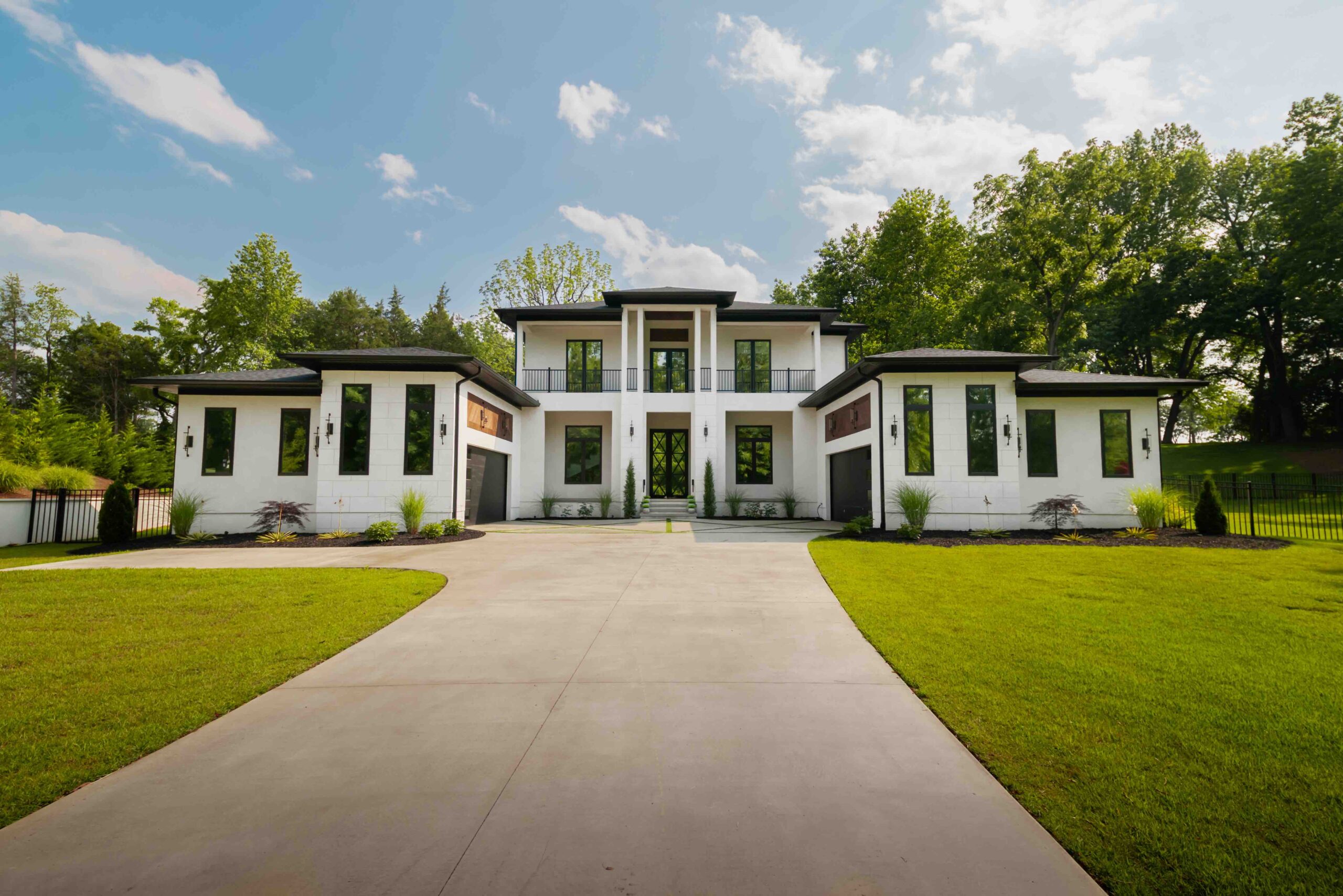 A white house with black roof with a reflective home window tint
