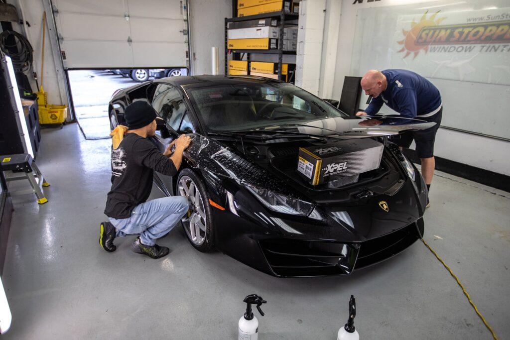 2 men putting ppf on a car