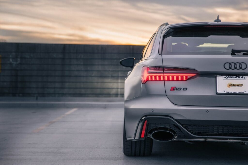 An Audi RS6 automobile sits parked as the sun sets.