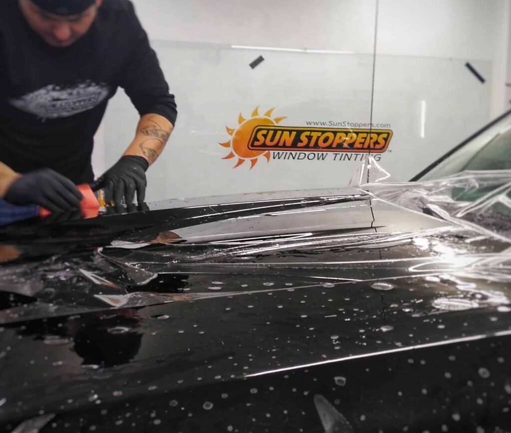 a Sun Stoppers worker putting ppf on a car