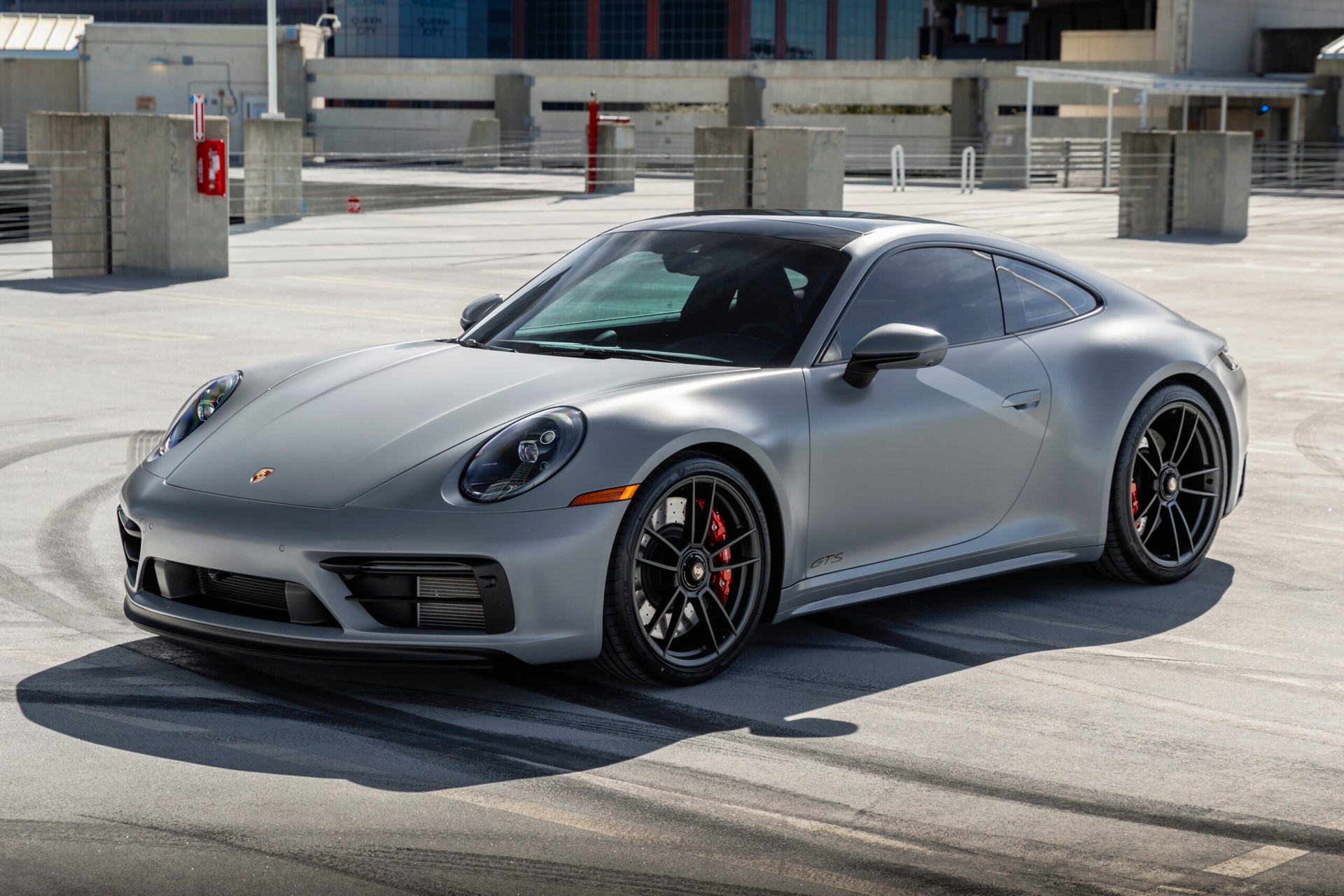 angled view of gray porsche on parking garage roof top