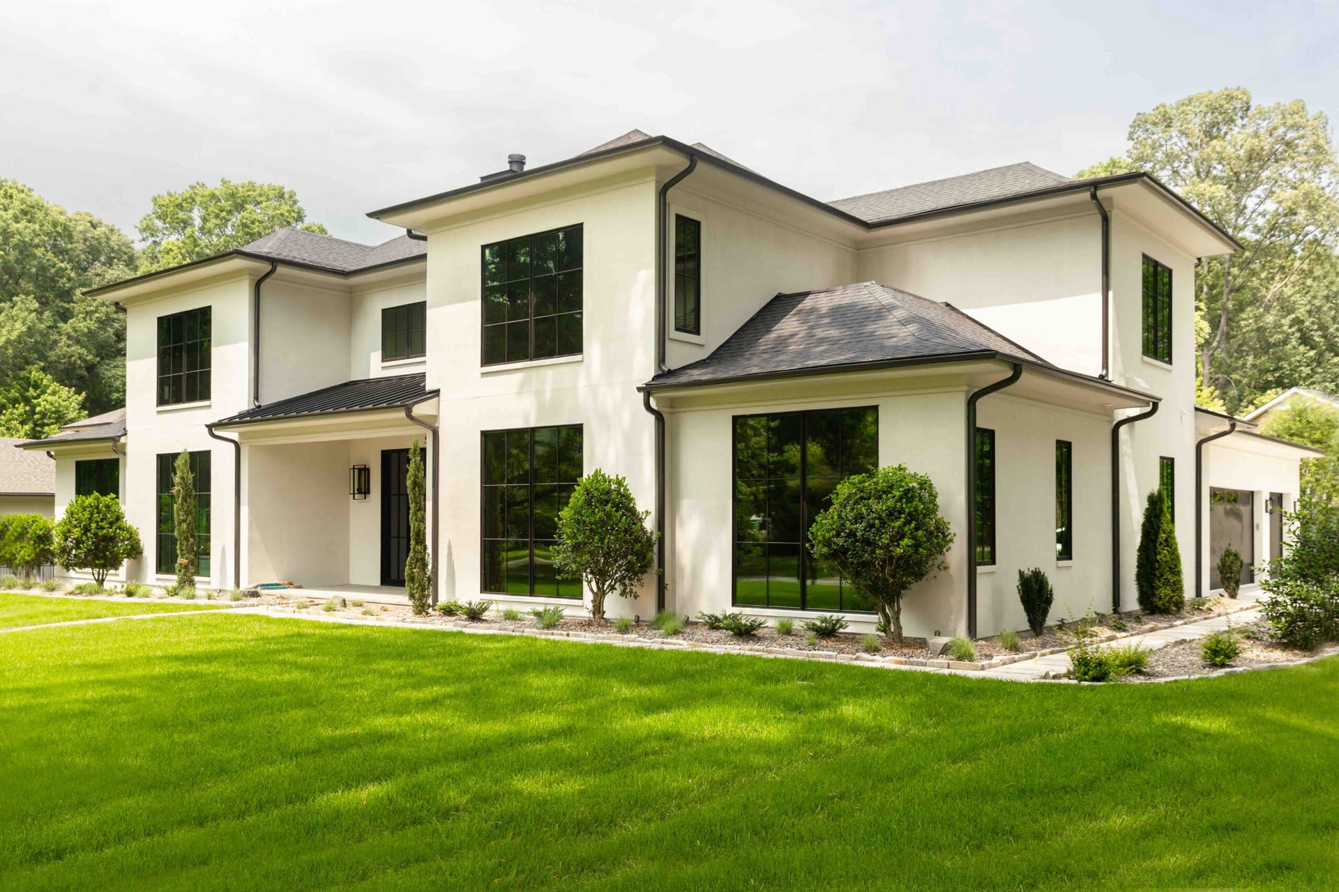 A white house with black roof with a new home window tint