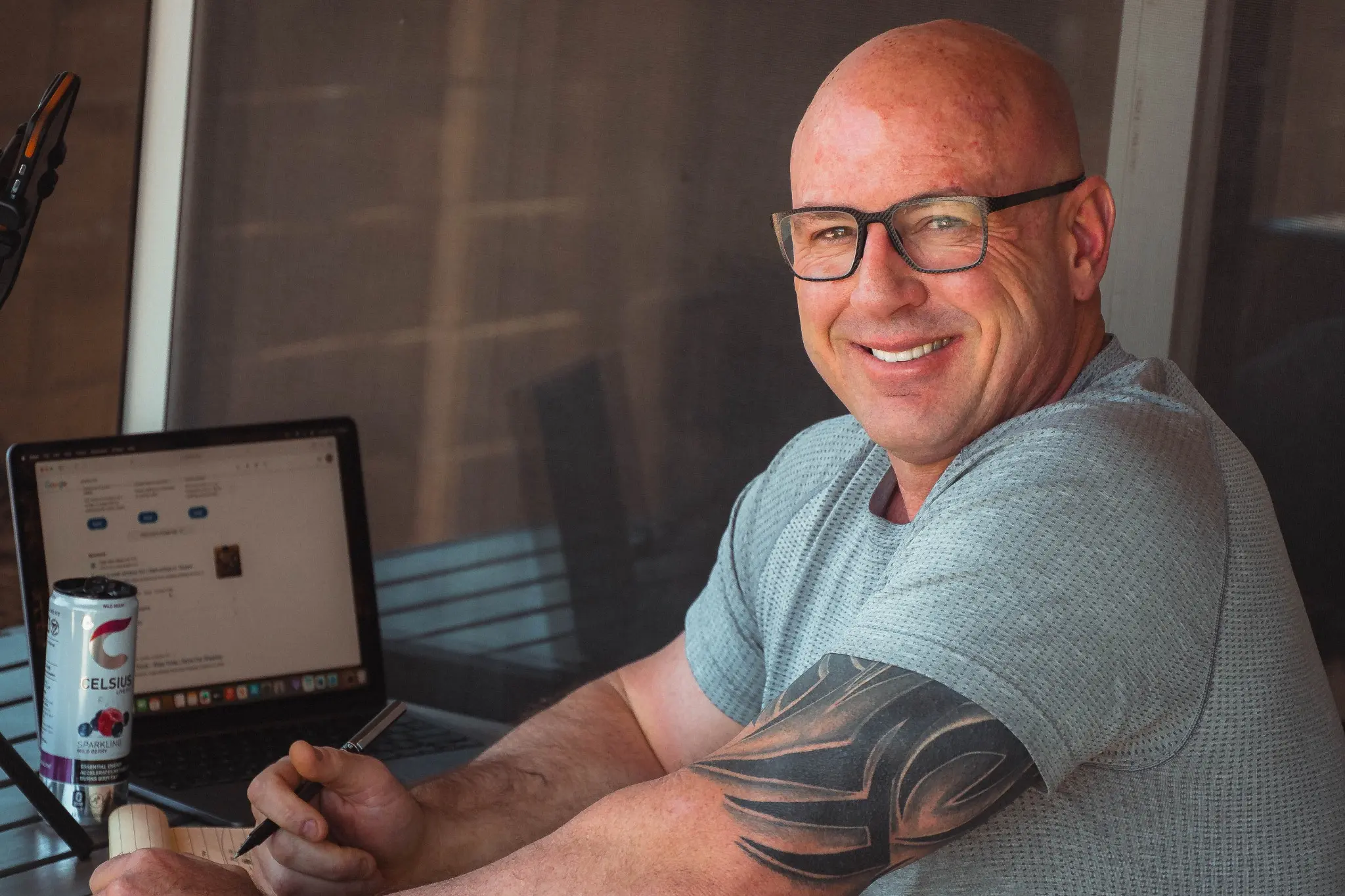 Sun Stoppers founder Mike Burke seated beside a laptop